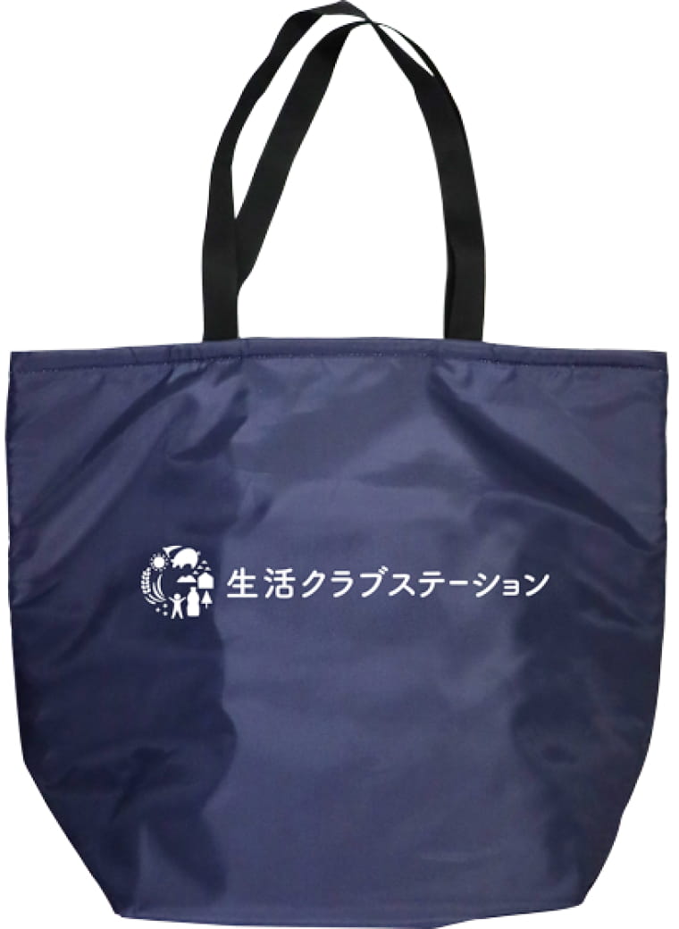 写真：生活クラブステーションのロゴが中央に配置されたエコバッグ。全面が光沢のあるナイロンで深い紺、持ち手は非光沢の黒。